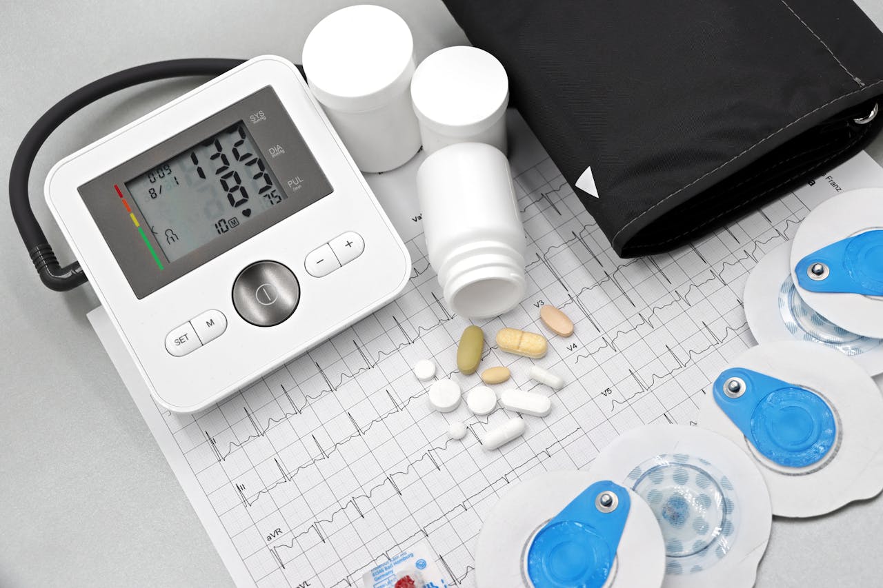 creative-03 Flat lay of blood pressure monitor, pills, and ECG printout for heart health theme.